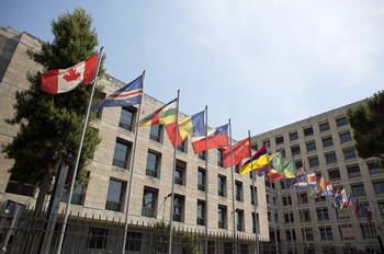 Row of country flags in front of a building.